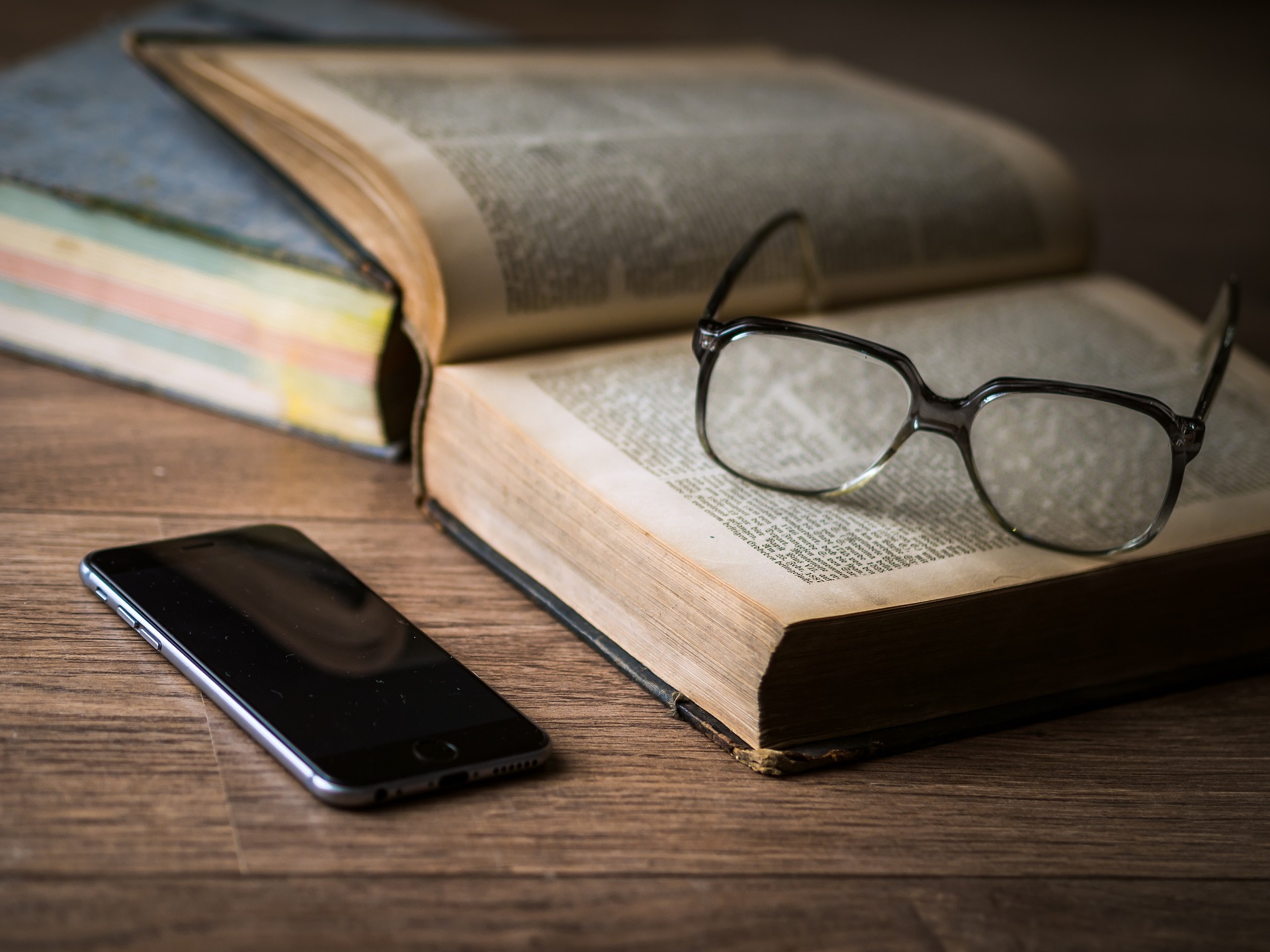 Open book, glasses, and cell phone